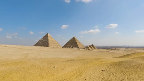 Panoramic-pan-left-to-establish-Great-Pyramids-of-Giza-in-center,-Egypt