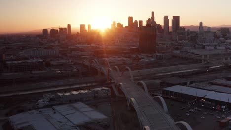 Descending-aerial-tilting-up-shot-of-the-Sixth-Street-Bridge-and-Viaduct-in-Los-Angeles,-California-at-sunset