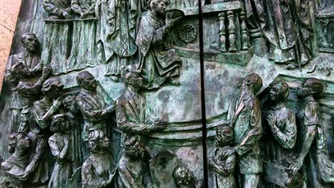 close-up-details-of-religious-gathering-depicted-on-bronze-church-door-of-Catedral-De-La-Almudena-in-Madrid