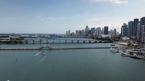 Aerial-view-of-boats-in-front-of-the-bridges,-in-front-of-the-Miami-skyline,-USA