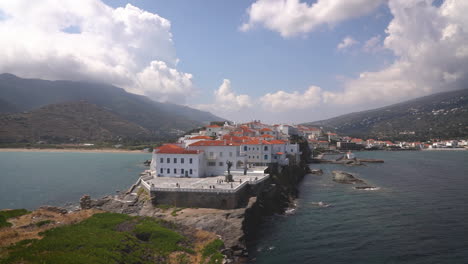 Pueblo-Costero-Con-Edificios-Blancos-Y-Tejados-Rojos-Ubicado-En-Una-Península-Rocosa,-Rodeado-De-Aguas-Turquesas.