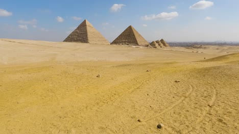 Yellow-golden-sands-at-base-of-Great-Pyramids-of-Giza-under-blue-sky