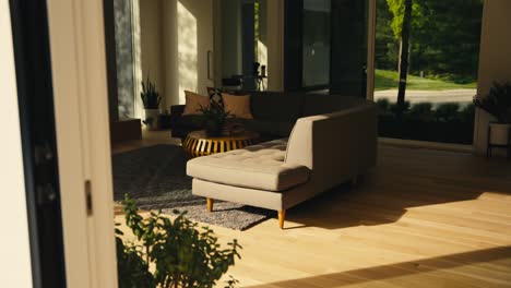 looking-in-through-a-sliding-door-at-the-sunrise-light-hitting-the-side-of-a-couch-in-the-living-room-of-a-luxury-home