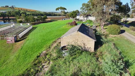 Aerial-reveal-of-an-old-storage-building-on-a-vineyard-in-the-Yarra-Valley-near-Yarra-Glen-in-Victoria-Australia