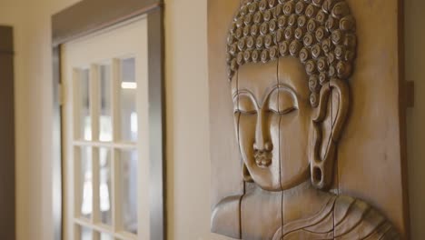 A-Buddha-wall-art-piece,-skillfully-crafted-by-hand,-adorns-the-wall