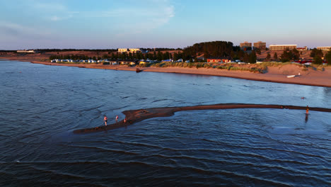 Luftaufnahme-Von-Vater-Und-Kindern,-Die-Im-Wasser-An-Der-Küste-Von-Kalajoki-Spielen,-Sonnenuntergang-In-Finnland
