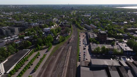 Toma-Aérea-De-Seguimiento-Sobre-El-Tren-Que-Sale-De-Tallin,-Estonia---Estación-De-Tren-Del-Báltico