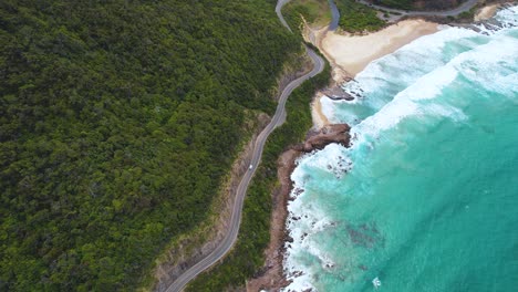 4K-Drone-view-of-a-camper-van-driving-along-the-Great-Ocean-Road-in-Victoria,-Australia