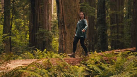 A-cute-girl-skips-through-a-redwood-forest