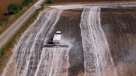 Luftaufnahme-Eines-Traktors,-Der-Mit-Sprinklern-Und-Einem-Staubunterdrückungssystem-Auf-Einem-Feld-Fährt