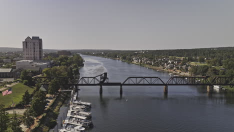 Augusta-Georgia-Aerial-v34-low-flyover-capturing-6th-St-railroad-bridge-spanning-across-Savannah-river,-riverwalk-park-and-downtown-cityscape-on-a-sunny-day---Shot-with-Mavic-3-Pro-Cine---October-2023