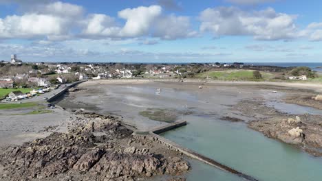 Bordeaux-Harbour-Guernsey-high-distant-circling-drone-shot-showing-whole-harbour-on-sunny-day-with-boats-on-hardstanding-and-drying-out-and-views-over-beach-and-towards-the-north-of-Guernsey