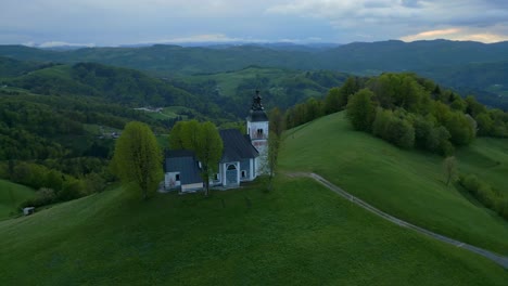 Aerial-orbit-shot-of-church-on-top-of-hill-in-Bukov-Vrh,-Slovenia