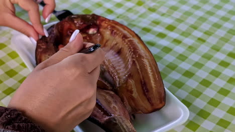 Primer-Plano-De-Manos-Femeninas-Cortando-Un-Plato-De-Marisco-Fresco-Cocinado-A-La-Parrilla-Servido-En-Una-Mesa-De-Restaurante