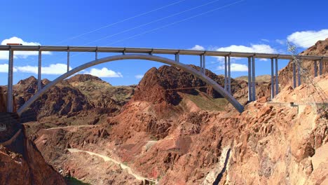 Hoover-Staudamm,-Gewölbte-Straßenbrücke-Mit-Rotem-LKW,-Der-Vor-Blauem-Himmel-In-Nevada,-USA-überquert