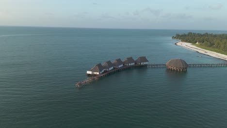 Aerial-view-orbiting-luxurious-thatched-roof-Kae-Funk-vacation-lodges-Indian-ocean-beach-resort-in-Zanzibar-Chwaka-bay