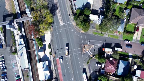 Landscape-view-of-cars-driving-near-main-road-lights-on-highway-neighbourhood-suburbs-street-train-station-Ourimbah-Australia-drone-aerial-transport-travel