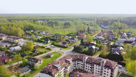 Beautiful-apartment-buildings-surrounded-by-green-forestry-landscape,-aerial-view