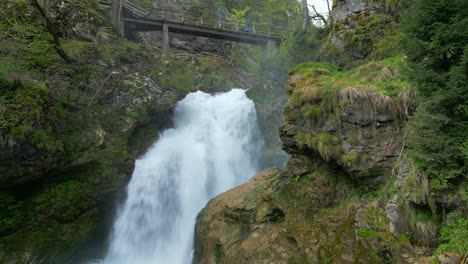 Wasserfall-Sum-Kaskade-Inmitten-üppigen-Grüns,-Mit-Einer-Rustikalen-Holzbrücke-überspannt