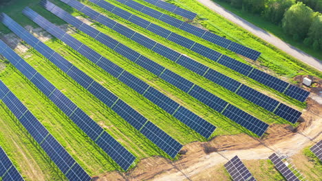 Luftaufnahme-Von-Sonnenkollektoren-Auf-Der-Grünen-Wiese,-Flugaufnahme-Eines-Solarparks