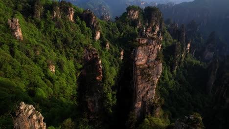 Drone-flying-over-karstic-pillars-in-Tianzi-Mountain-at-sunset-with-stunning-views