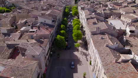 Aerial-tilting-shot-revealing-cars-driving-through-the-antique-city-of-Pezenas