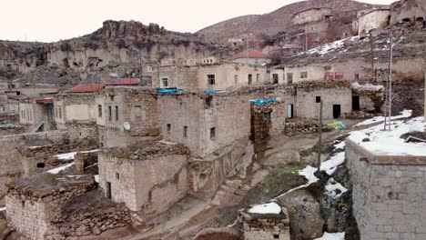 Casas-De-Pueblo-Del-Medio-Oriente-En-La-Nieve-Del-Invierno-En-El-Pueblo-Cerca-Del-Monasterio-De-Las-Cuevas-De-Selime-Cerca-De-Capadocia,-Turquía---Cappadocia,-Turkey
