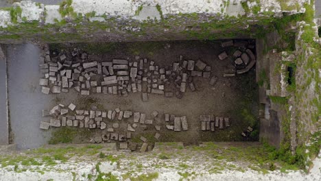 Broken-excavated-bricks-from-overgrown-decrepit-hallway-in-Claregalway-Friary-monastery-ruins