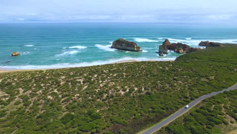 4k-Drone-video-panning-up-and-around-the-winding-road-along-the-coast-of-the-Great-Ocean-Road-in-Victoria,-Australia