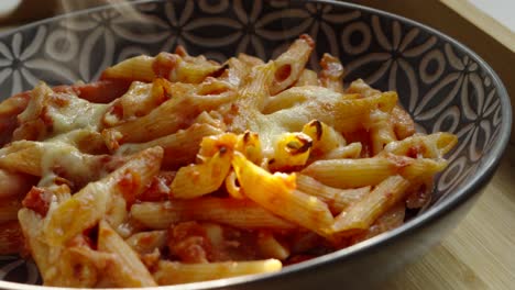 Nahaufnahme-Von-Würzigen-Arrabiata-Penne-Nudeln-Mit-Aufsteigendem-Dampf-Im-Abendlicht