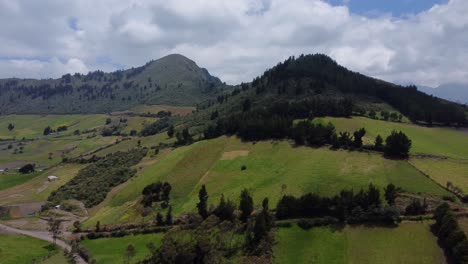 Aerial-Drone-Flyover-Push-Of-Farms-And-Forested-Mountain-Peaks