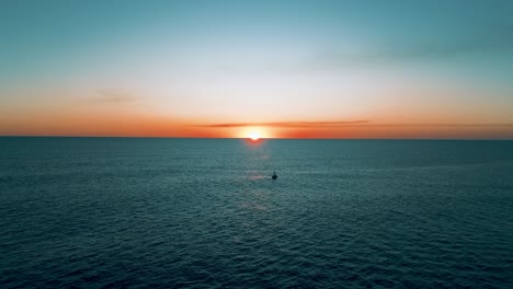 Wunderschöner-Sonnenuntergang-Mit-Warmen-Tönen,-Luftaufnahme-Mit-Einer-Drohne,-Die-über-Den-Pazifischen-Ozean-Und-Den-Strand-In-El-Salvador-Fliegt,-Mit-Einem-Boot-Im-Vordergrund
