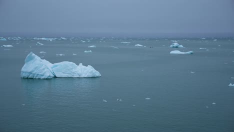 Sailing-by-Icebergs-and-Pieces-of-Ice-in-Cold-Arctic-Sea-on-Misty-Day