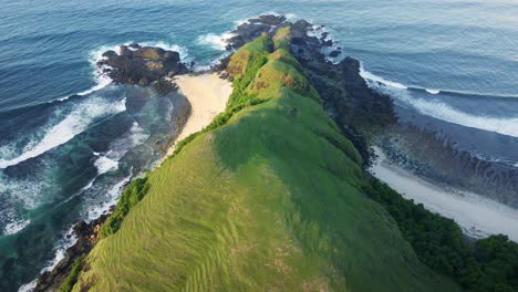 Epic-view-of-Merese-Hills,-mandalika,-Lombok-Island-with-stunning-waves-crashing-over-the-cliffs-and-the-white-sandy-shore-below-the-hills