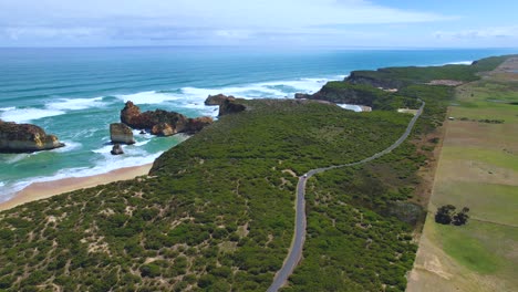 4K-Drone-Video-following-along-the-Camper-Van-that-is-driving-along-the-Great-Ocean-Road-in-Victoria,-Australia