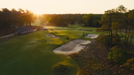 drone-shot-of-golf-course-maintenance-workers-or-grounds-crew-prepping-a-green-during-sunrise