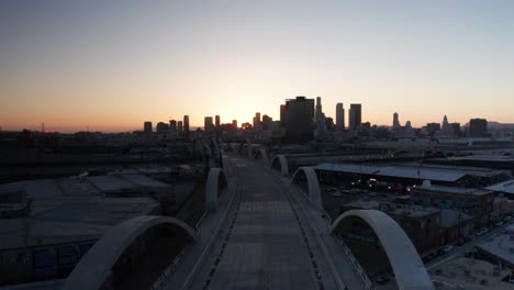 Low-aerial-shot-flying-over-the-Sixth-Street-Bridge-and-Viaduct-at-sunset-in-downtown-Los-Angeles,-California