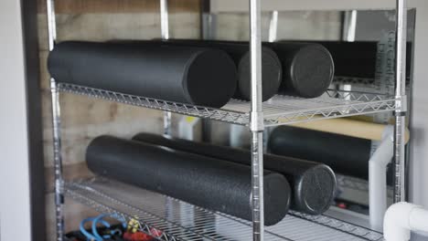 An-image-showcasing-foam-rollers-neatly-arranged-on-a-gym-shelf-in-a-close-up-view