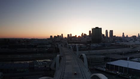 Wide-rising-aerial-shot-of-the-Sixth-Street-Bridge-and-Viaduct-in-downtown-Los-Angeles,-California-at-sunset