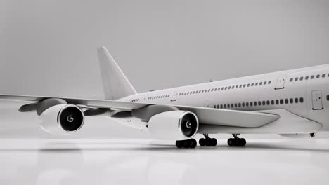White-airplane-3D-model-on-white-background,-3D-animation,-camera-zoom-out