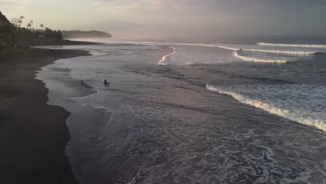 Playa-De-Surfistas-Balianos-Con-Una-Silueta-De-Surfista-Solitaria-Caminando-Para-Atrapar-Algunas-Olas-Tranquilas