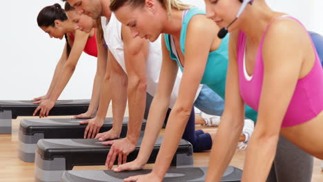 Aerobics-class-doing-press-ups-together-led-by-instructor
