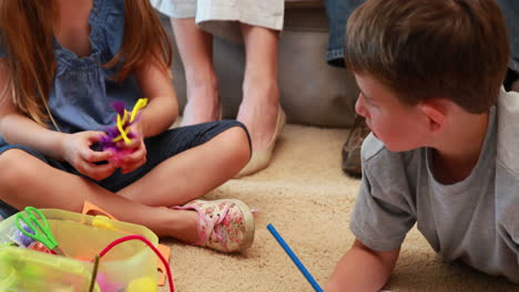 Young-siblings-doing-arts-and-crafts-on-the-rug-