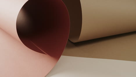 Nahaufnahme-Von-Zwei-Brauntönen-Aufgerolltem-Papier-Auf-Weißem-Hintergrund-Mit-Kopierraum-In-Zeitlupe