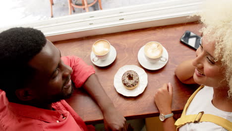 Ein-Glückliches-Paar,-Bestehend-Aus-Einem-Jungen-Afroamerikaner-Und-Einer-Jungen-Frau-Mit-Gemischter-Abstammung,-Genießt-Gemeinsam-Kaffee