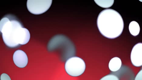 Animation-of-glowing-light-spots-moving-over-red-and-black-background