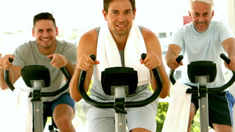 Group-of-men-in-fitness-studio-on-exercise-bikes