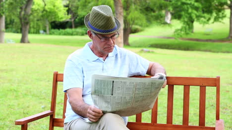 Retired-man-reading-the-paper-on-a-park-bench