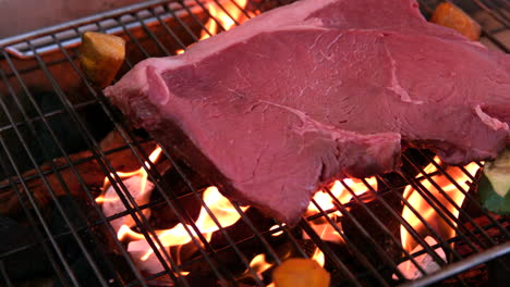 Large-steak-being-cooked-on-flaming-barbecue