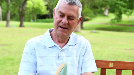 Retired-man-reading-on-a-park-bench